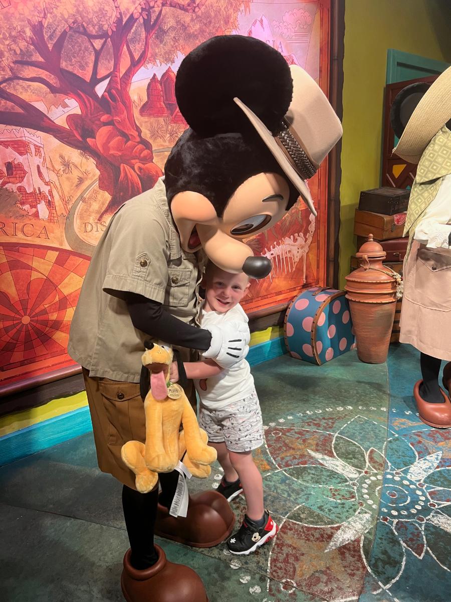 A child enjoying a Disney vacation with Mickey Mouse